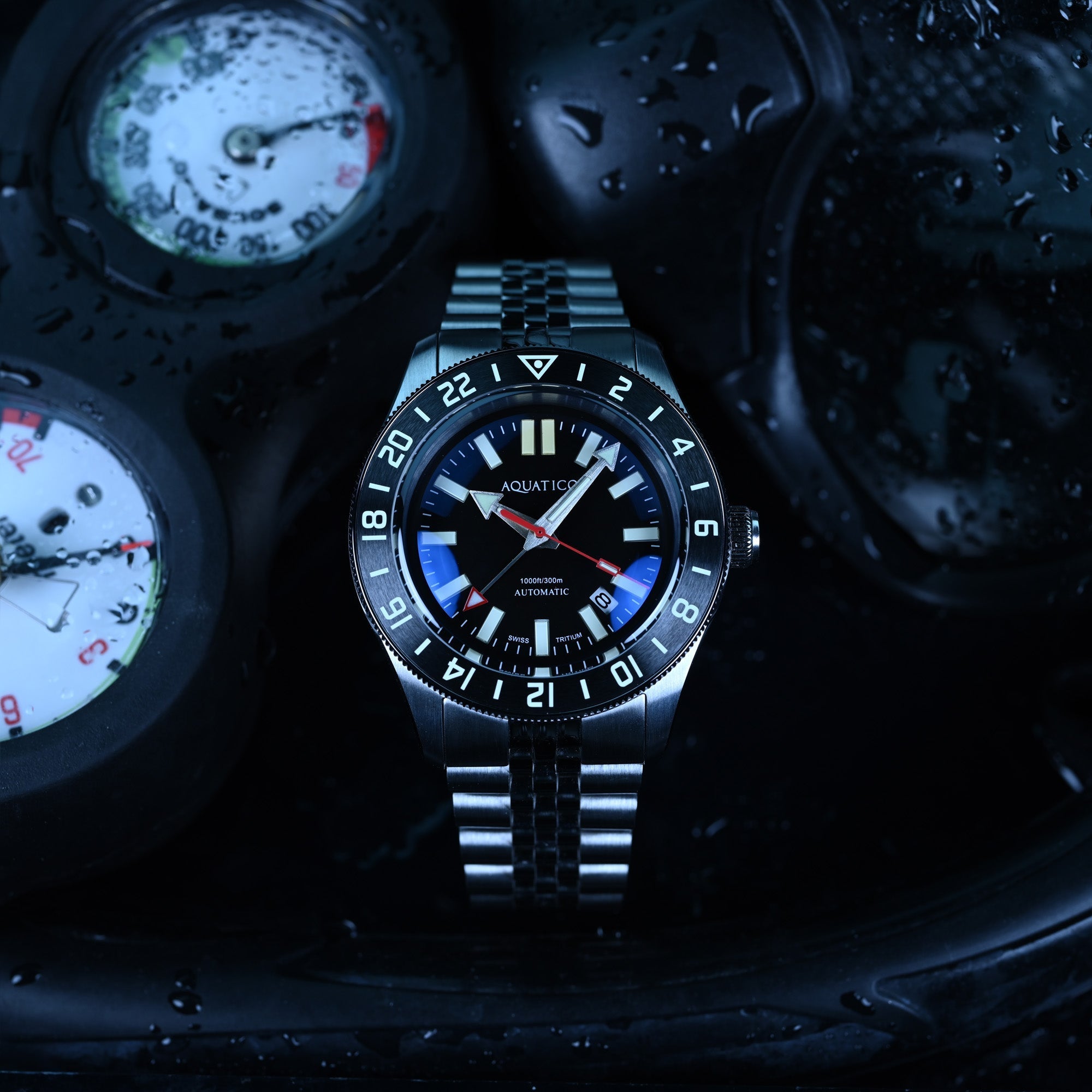 Aquatico Sea Recon GMT black dial watch beside dive equipment
