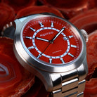 Close-up of bronze case and polished red agate watch dial